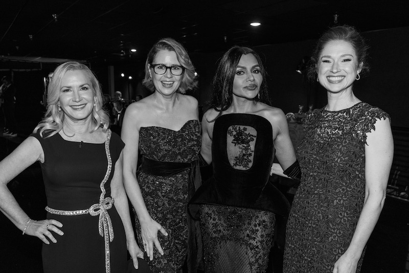 A group of well-dressed women smile for the camera.