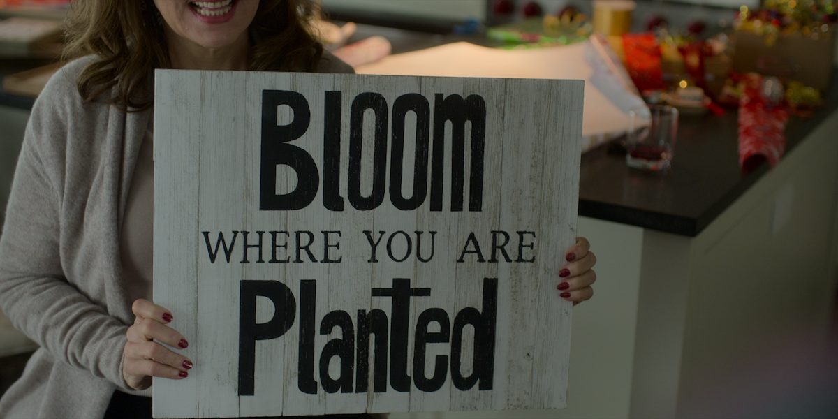 A sign on the wall of a suburban home reads