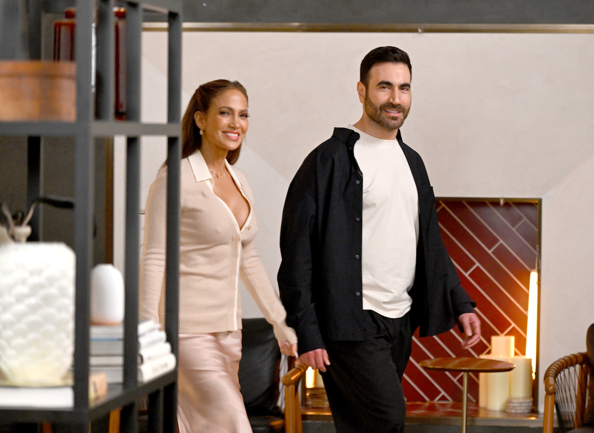 Jennifer Lopez and Brett Goldstein turn a corner to surprise and greet a group of people attending a speed-dating event.