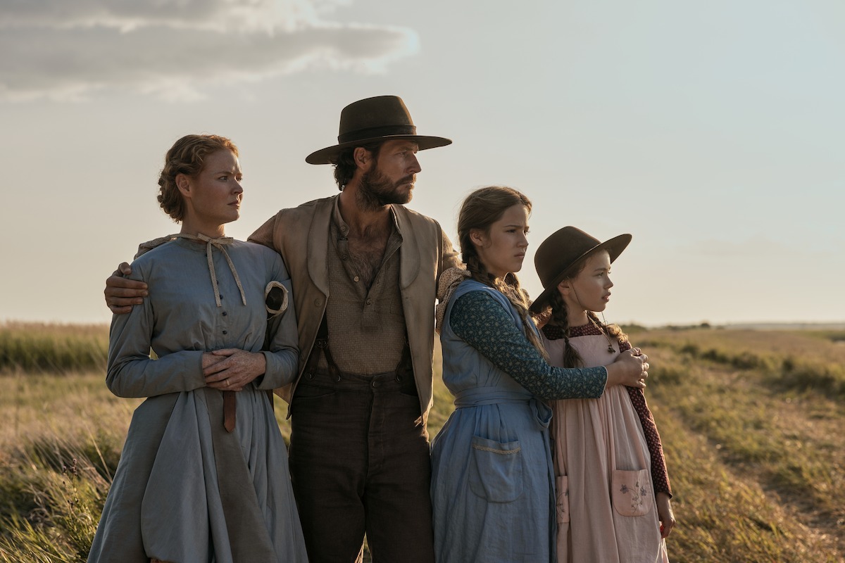 A family stands together and looks off to the distance.