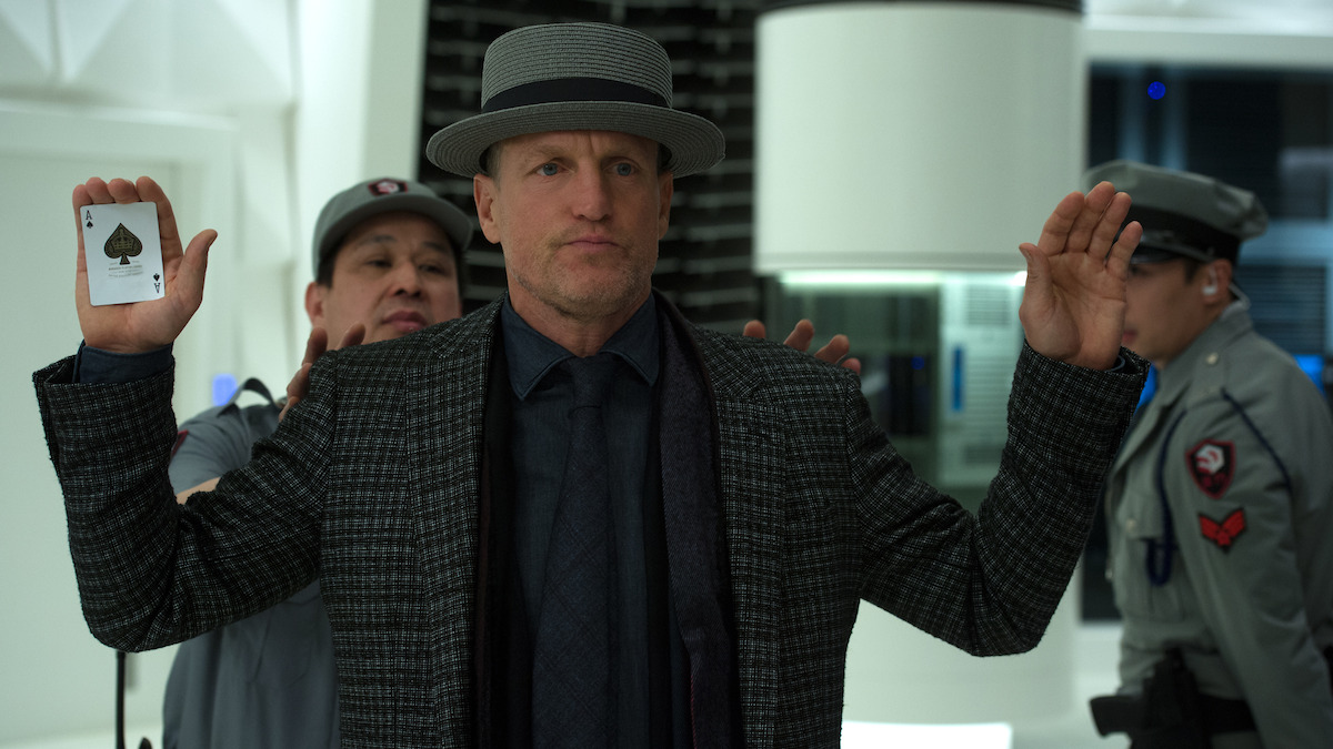 Woody Harrelson holds his hands up, with an ace playing card in one hand, in the film ‘Now You See Me 2.’