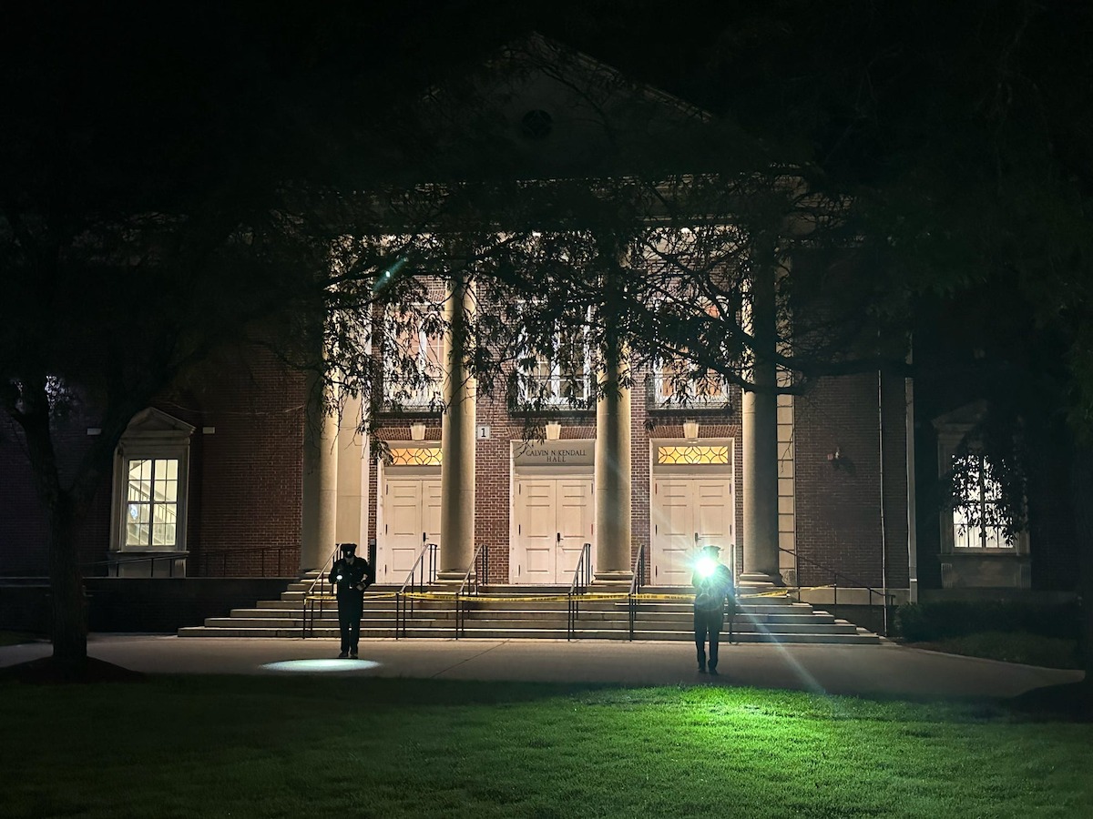 The Unsolved Mysteries crew recreates the search investigators embarked on. Two men using flashlights in the darkness.