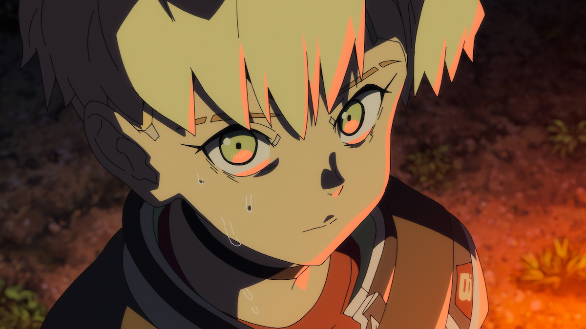 Anime character with blonde and dark hair, sweating and looking intense, illuminated by orange light in an outdoor environment with dirt and small plants in the background, suggesting a dramatic or tense moment.
