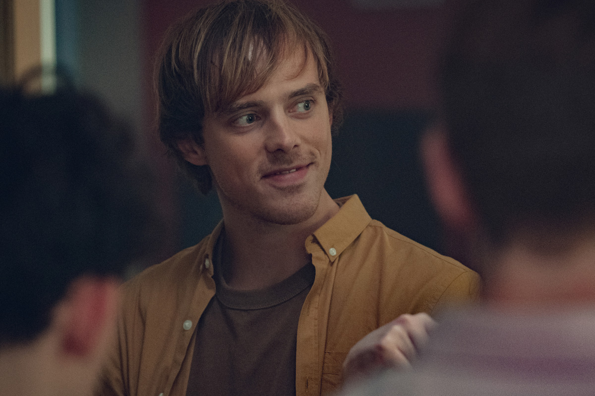Jack Barton as David smirks at a table in Season 2 of ‘Heartstopper.’