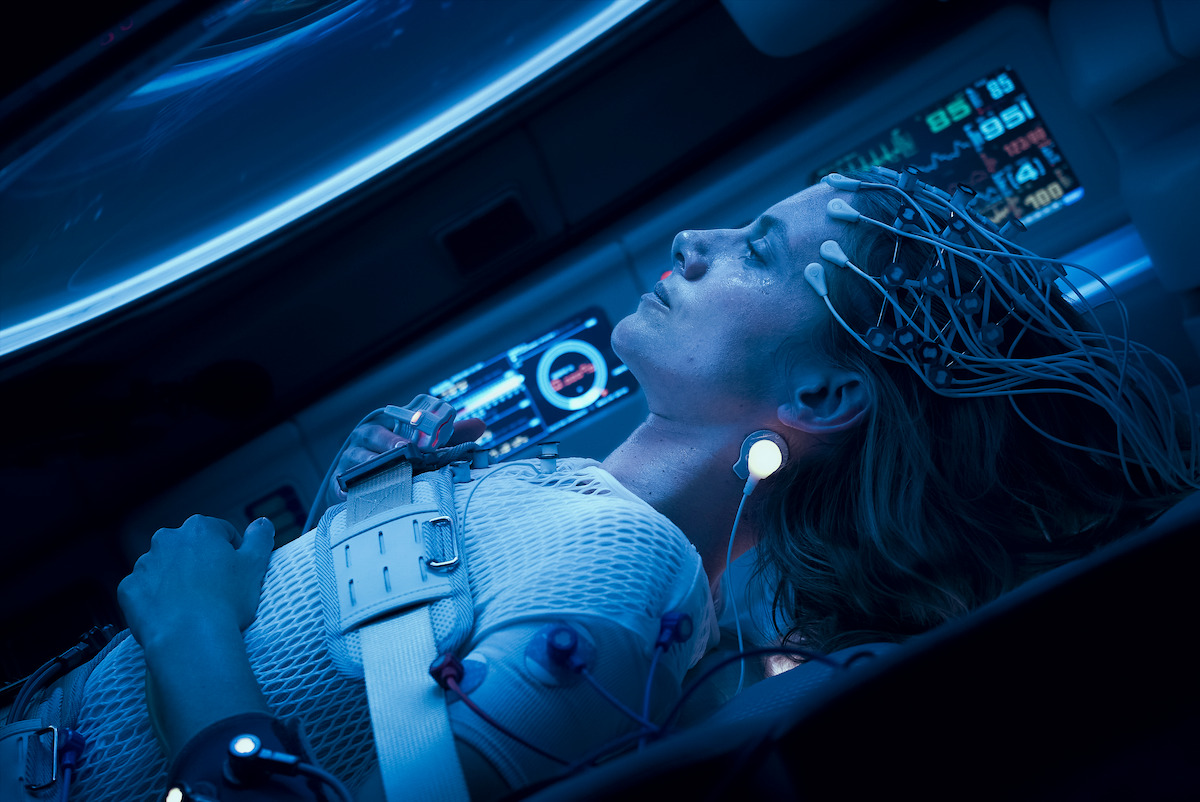 A woman sleeps in a bed with electrodes on her head