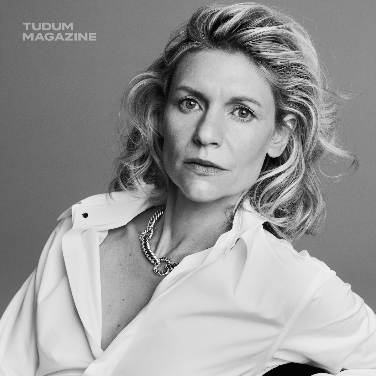 Claire Danes wears a white blouse and necklace as she poses for the camera.