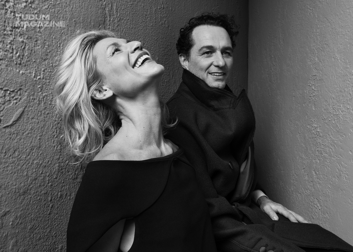 Claire Danes and Matthew Rhys pose for the camera, wearing all black and laughing.