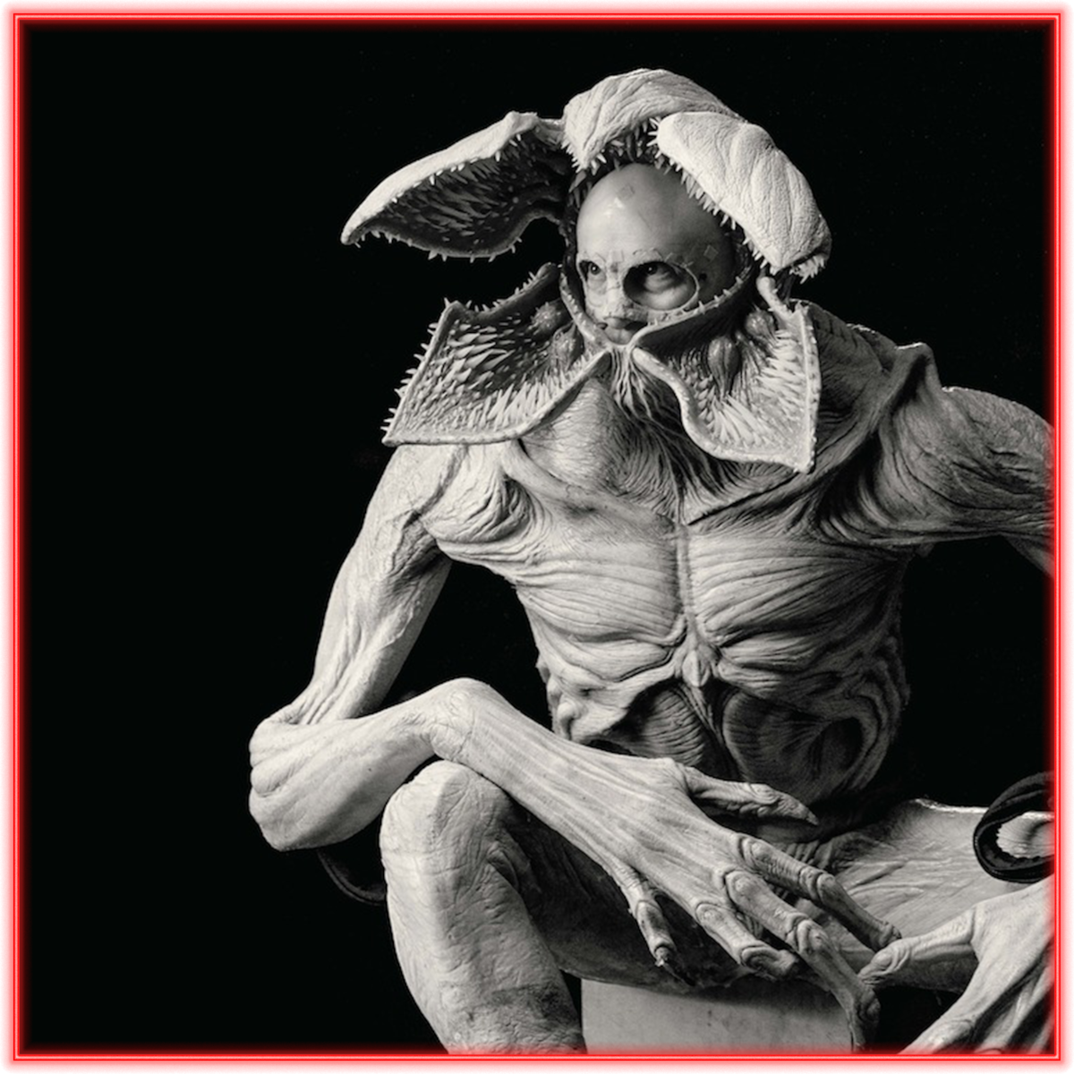 A detailed, menacing creature with petal-like head, humanoid muscular body, and elongated limbs sits in a dark, minimal setting; black background, red border frames the image, emphasizing the horror and fantasy atmosphere.