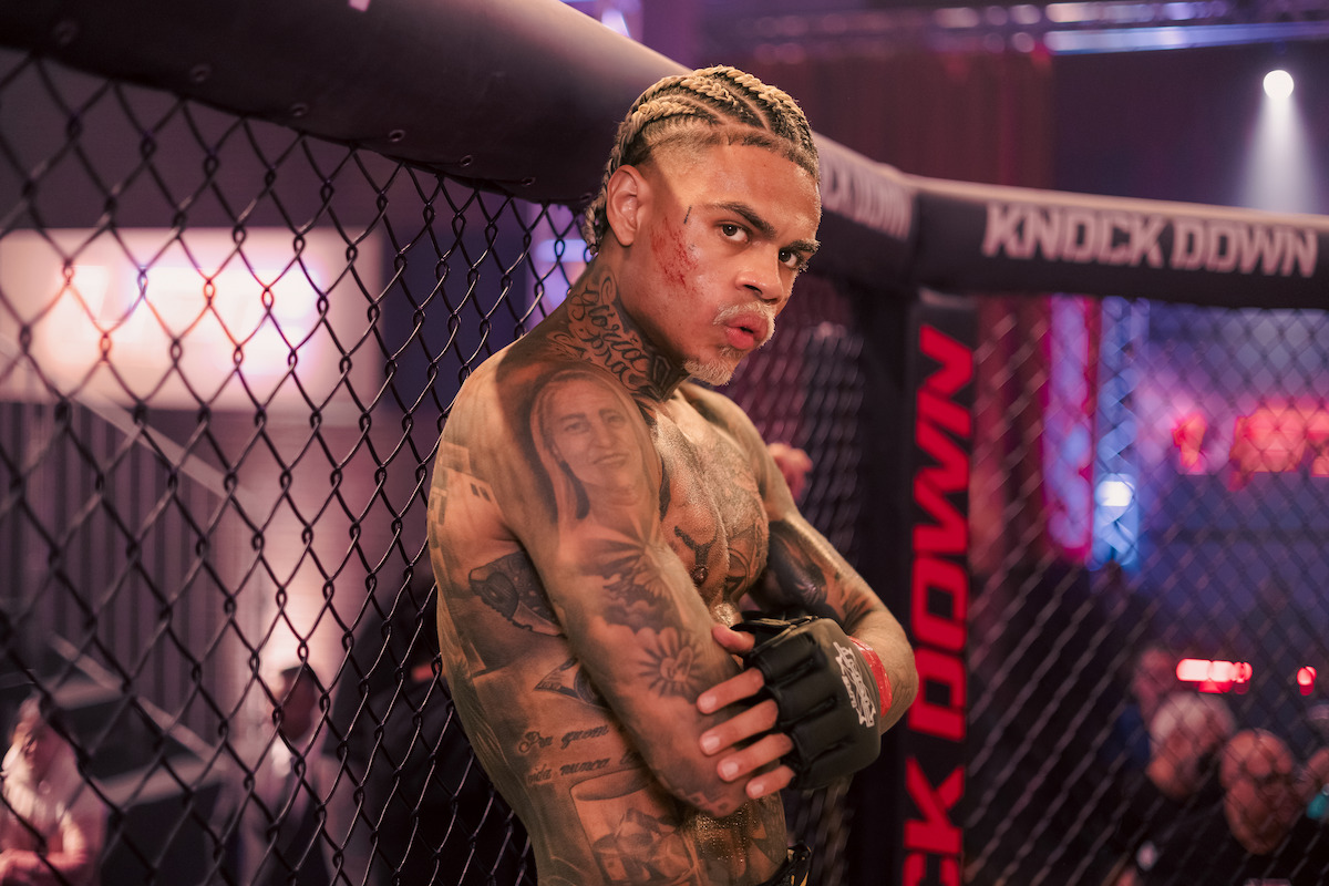 Lutador de MMA interpretado por MC Cabelinho repousa na grade de um ringue