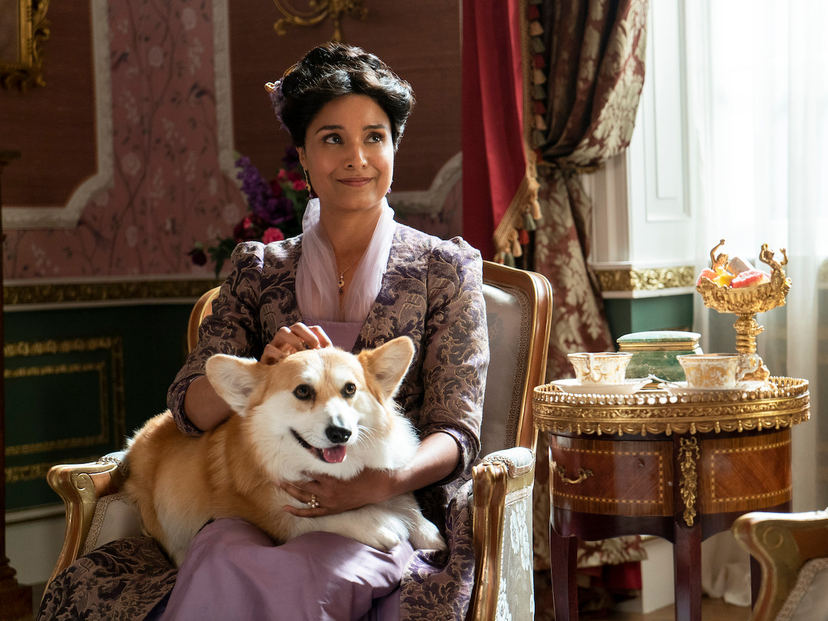 Lady Mary smiles with Newton the dog on her lap.