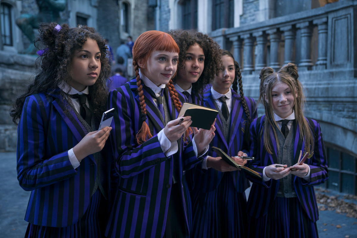 Evie Templeton as Agnes DeMille stands with friends at Nevermore Academy in ‘Wedneday’ Season 2.