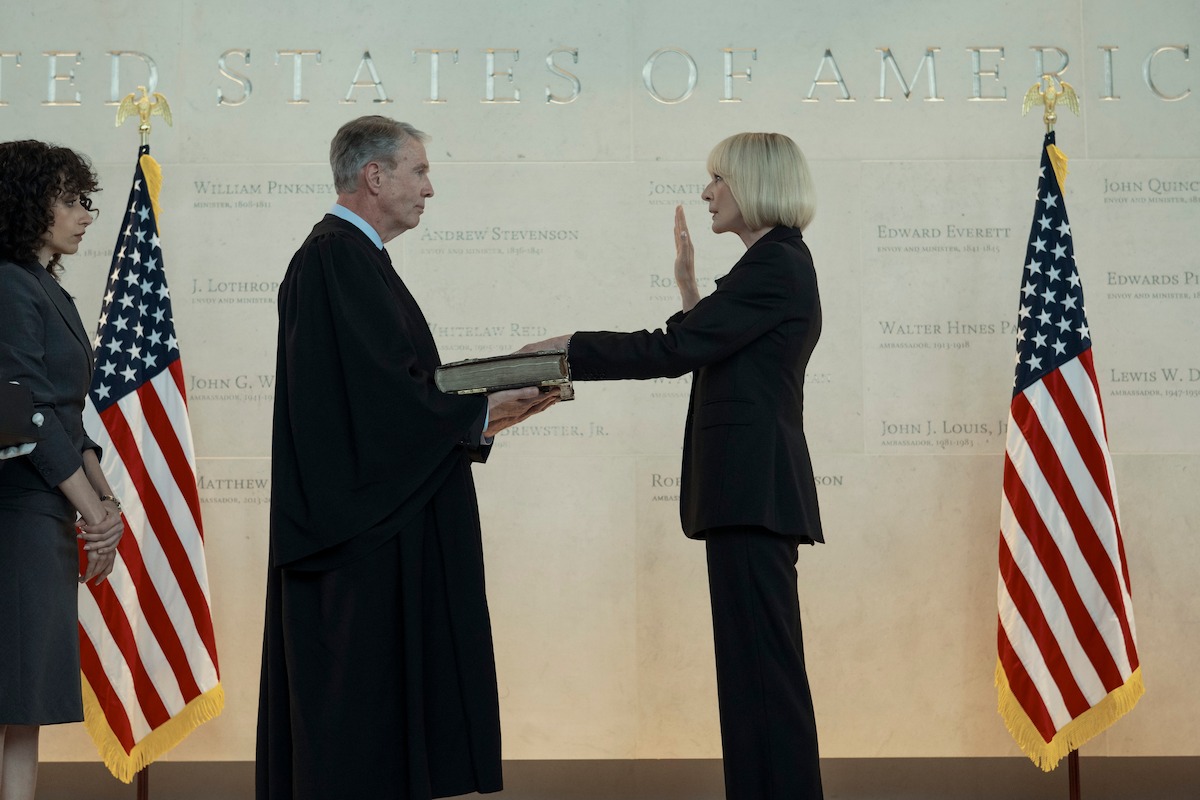 Allison Janney as President Penn holds up her right hand with her left hand on the bible as she’s sworn in as president of the United States.
