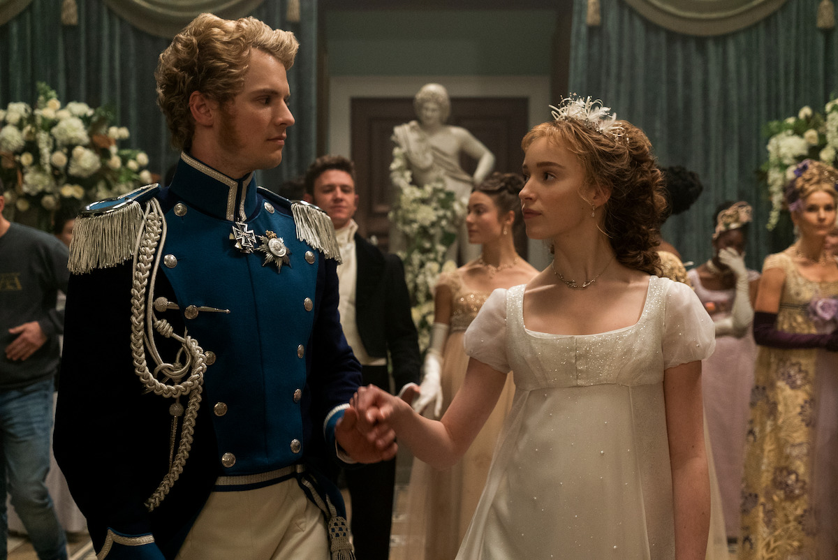 Freddie Stroma as Prince Friedrich and Phoebe Dynevor as Daphne Bridgerton walk to the dance floor together in Season 1 of ‘Bridgerton.’