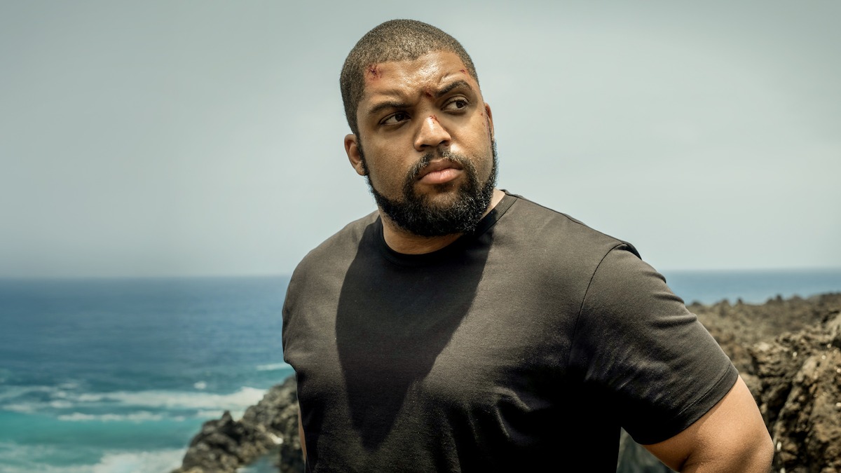 O’Shea Jackson Jr. stands in front of a rocky shore in ‘Den of Thieves 2: Pantera.’