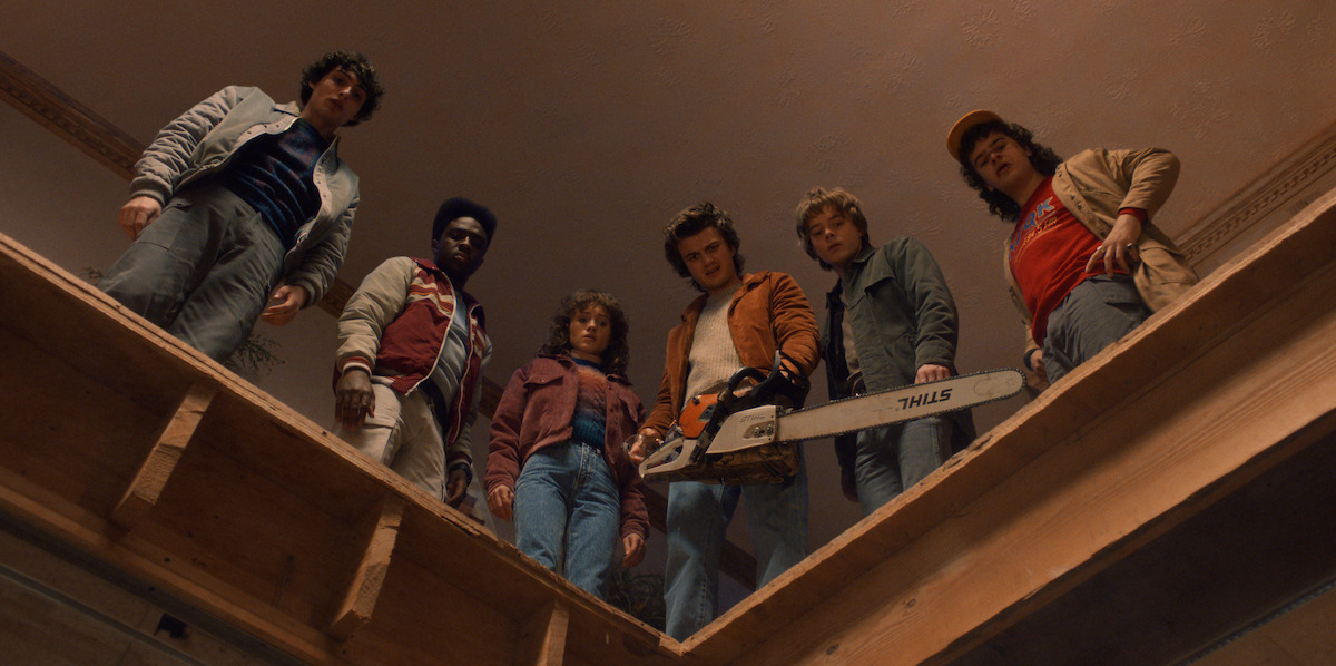 Finn Wolfhard as Mike, Caleb McLaughlin as Lucas, Natalia Dyer as Nancy, Joe Keery as Steve, Charlie Heaton as Jonathan and Gaten Matarazzo as Dustin look down in ‘Stranger Things 5’