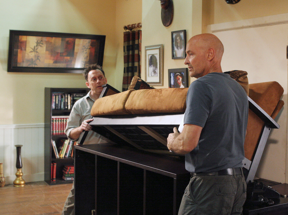 Michael Emerson and Terry O'quinn barricading a door together. 