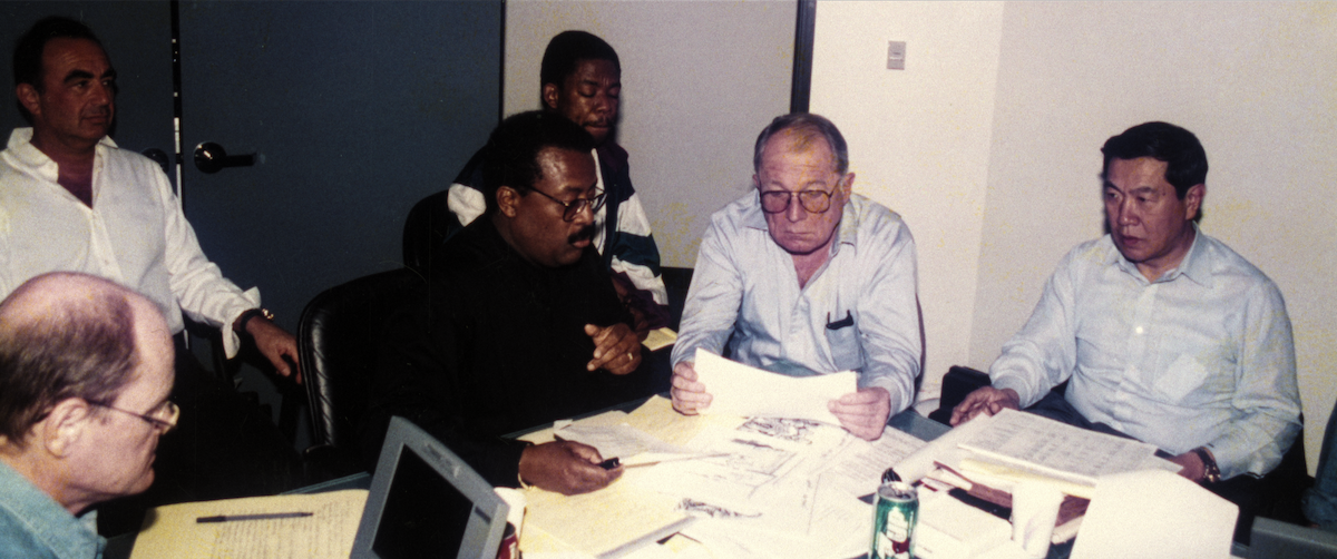 A group of men looking at case files