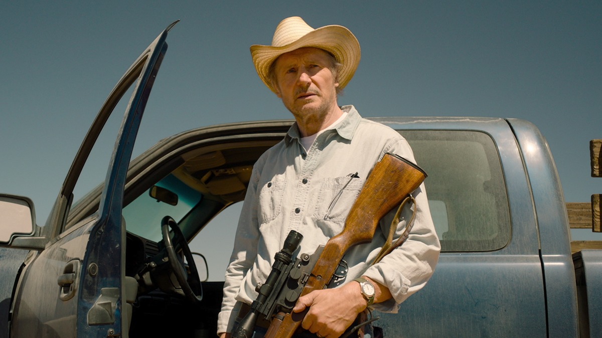Liam Neeson as Jim Hanson readies his gun in ‘The Marksman.’