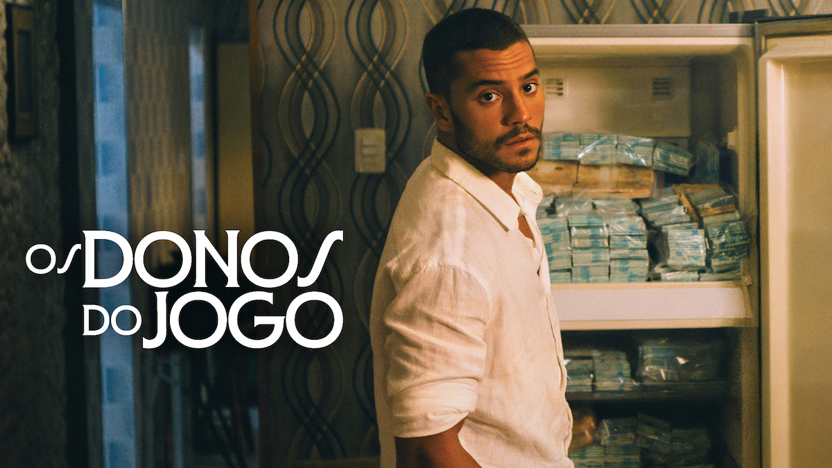 André Lamoglia guarda dinheiro em um freezer doméstico, em poster da série "Os Donos do Jogo"