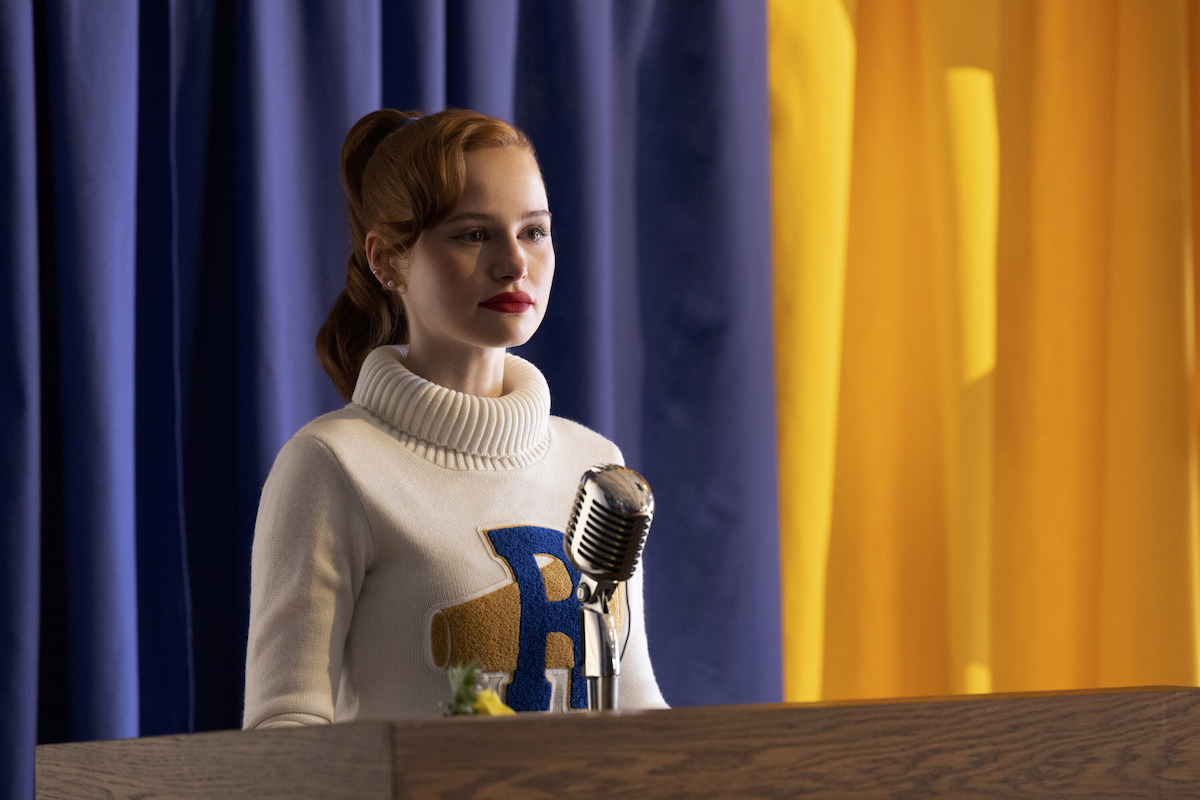 Madelaine Petsch as Cheryl Blossom stands at a podium in Season 7 of ‘Riverdale.’