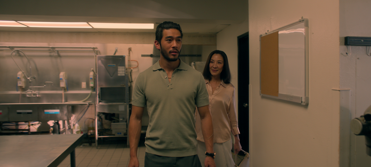 Justin Chien as Charles Sun and Michelle Yeoh as Eileen Sun walk through the kitchen of a bakery in season 1 of ‘The Brothers Sun’