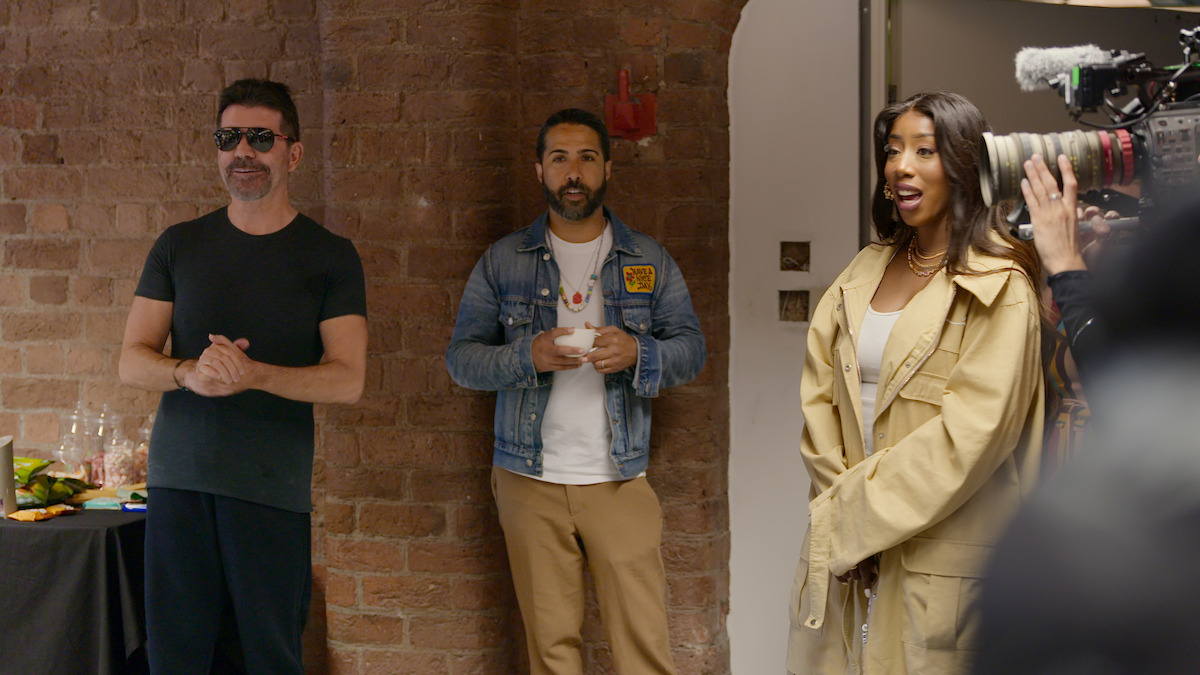 Simon, Savan and Kamille stand in a room.