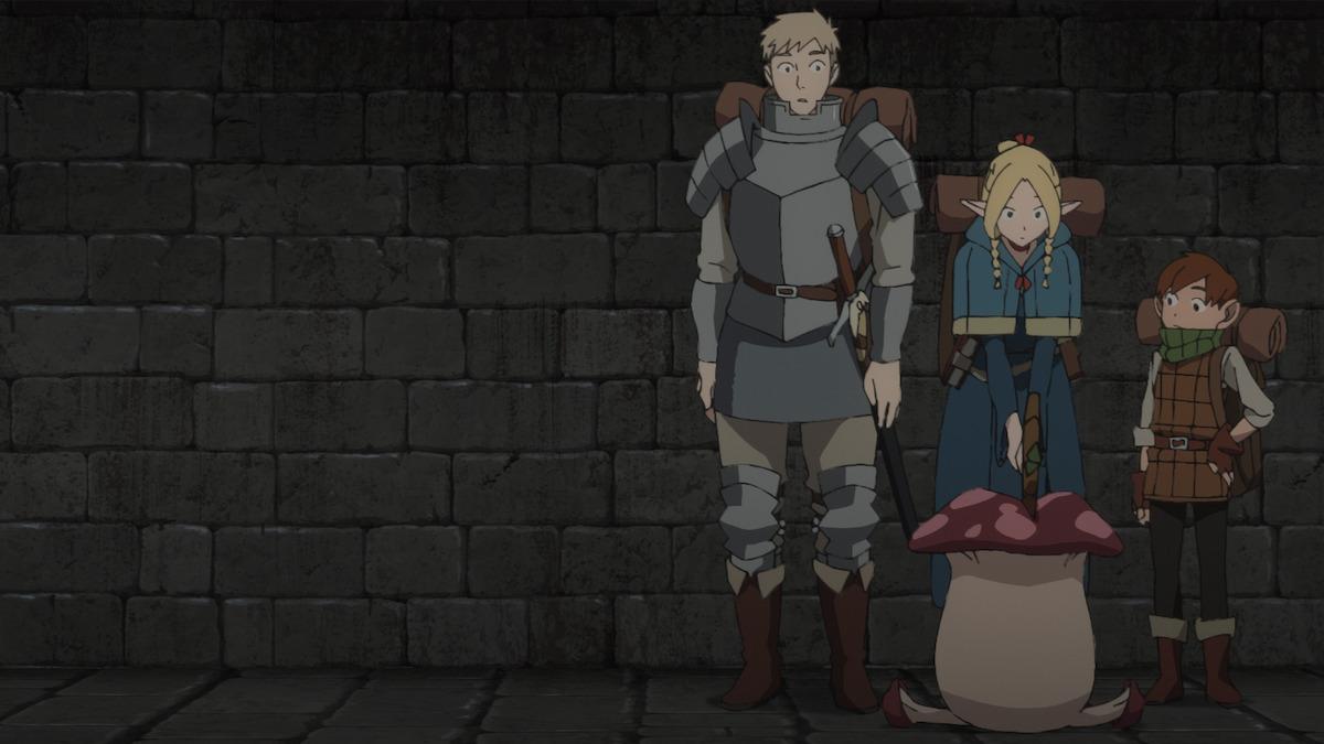 In an image from the animated series ‘Delicious in Dungeon,’ three characters stand against a wall.