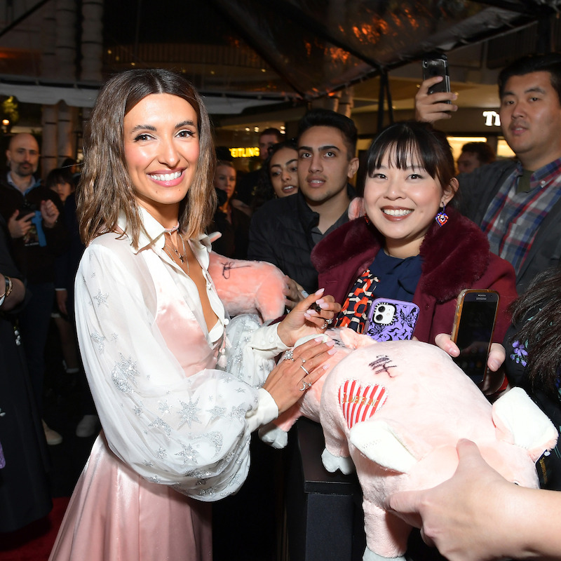 India de Beaufort signs stuffed pigs for fans in the pink gown that she designed herself (which included glueing glitter stars onto the sleeves). 