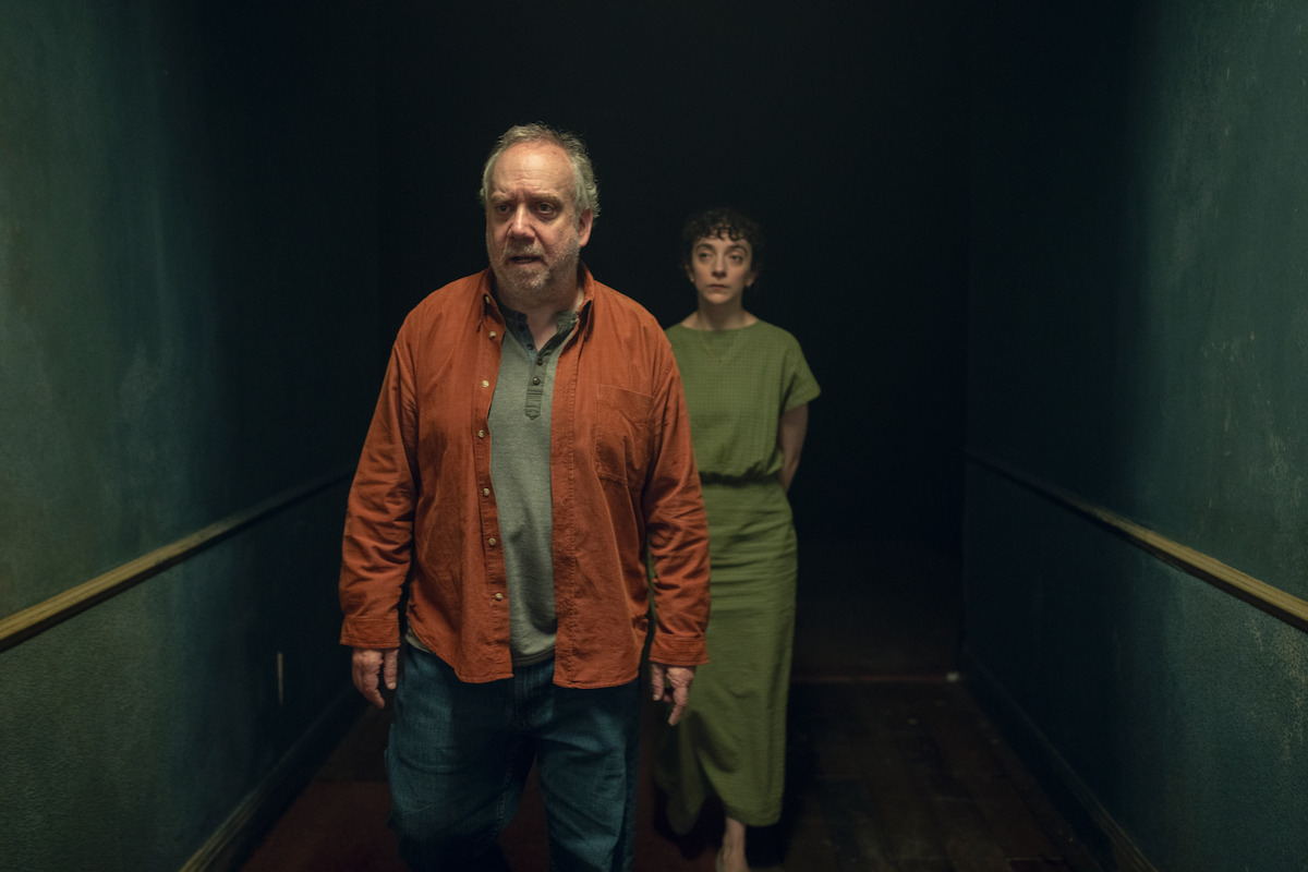 Patsy Ferran and Paul Giamatti walk through a hallway together in Season 7 of ‘Black Mirror’