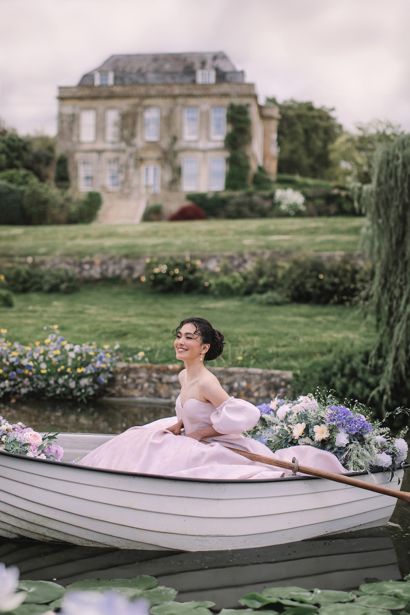 Woman in bridal dresses poses and looks off into the distance.