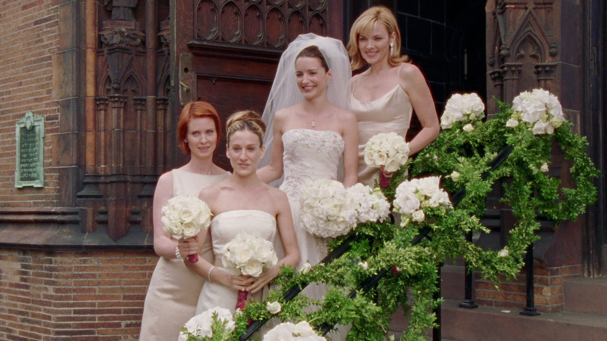 Charlotte in a white wedding dress surrounded by Carrie, Miranda and Samantha. 