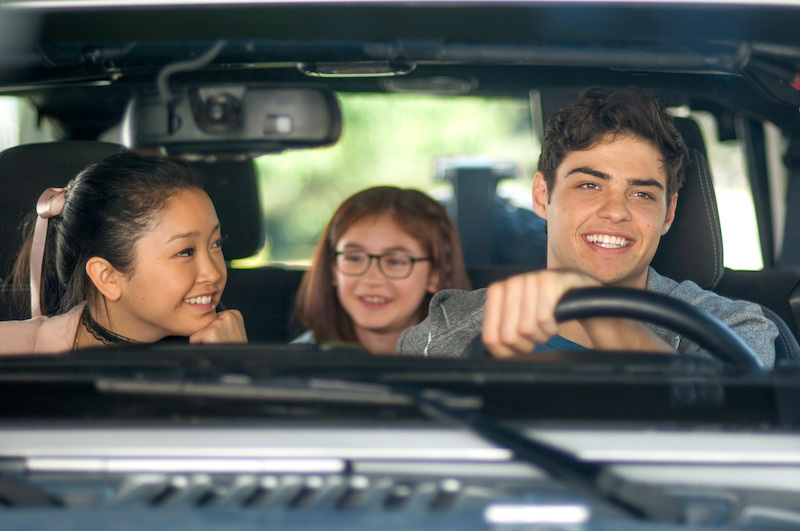 Lana Condor as Lara Jean, Anna Cathcart as Kitty, and Noah Centineo as Peter inside a car.
