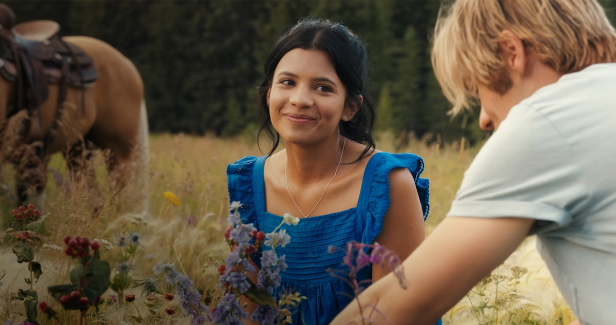 Nikki Rodriguez as Jackie Howard sits in a field of flowers in Season 1 of 'My Life With the Walter Boys'