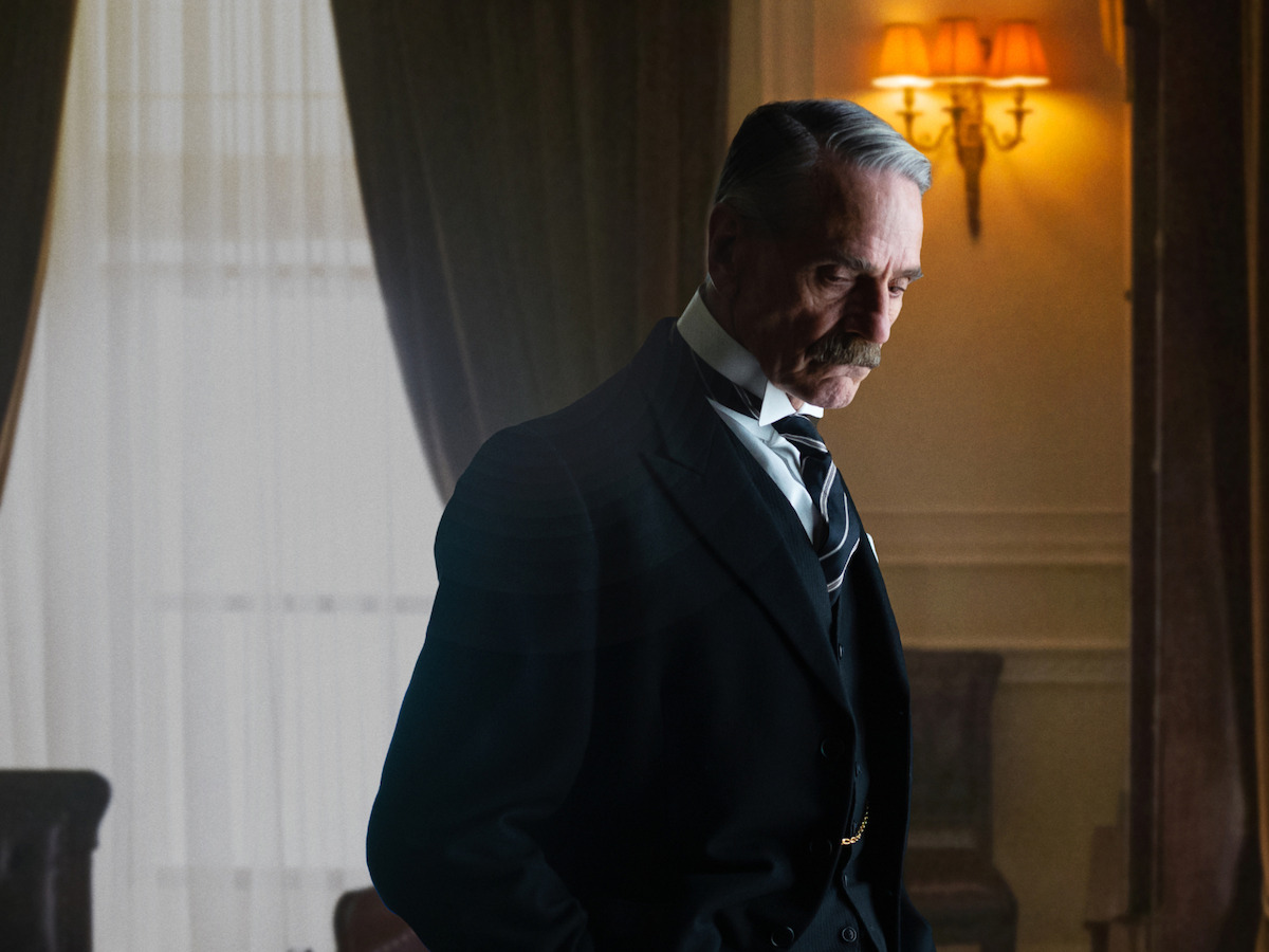 Jeremy Irons portrays Neville Chamberlain looking down, pondering
