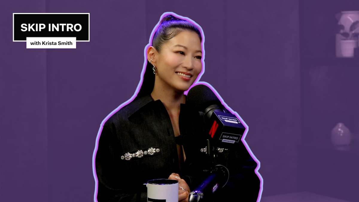 Arden Cho behind a podcast mic on a purple background