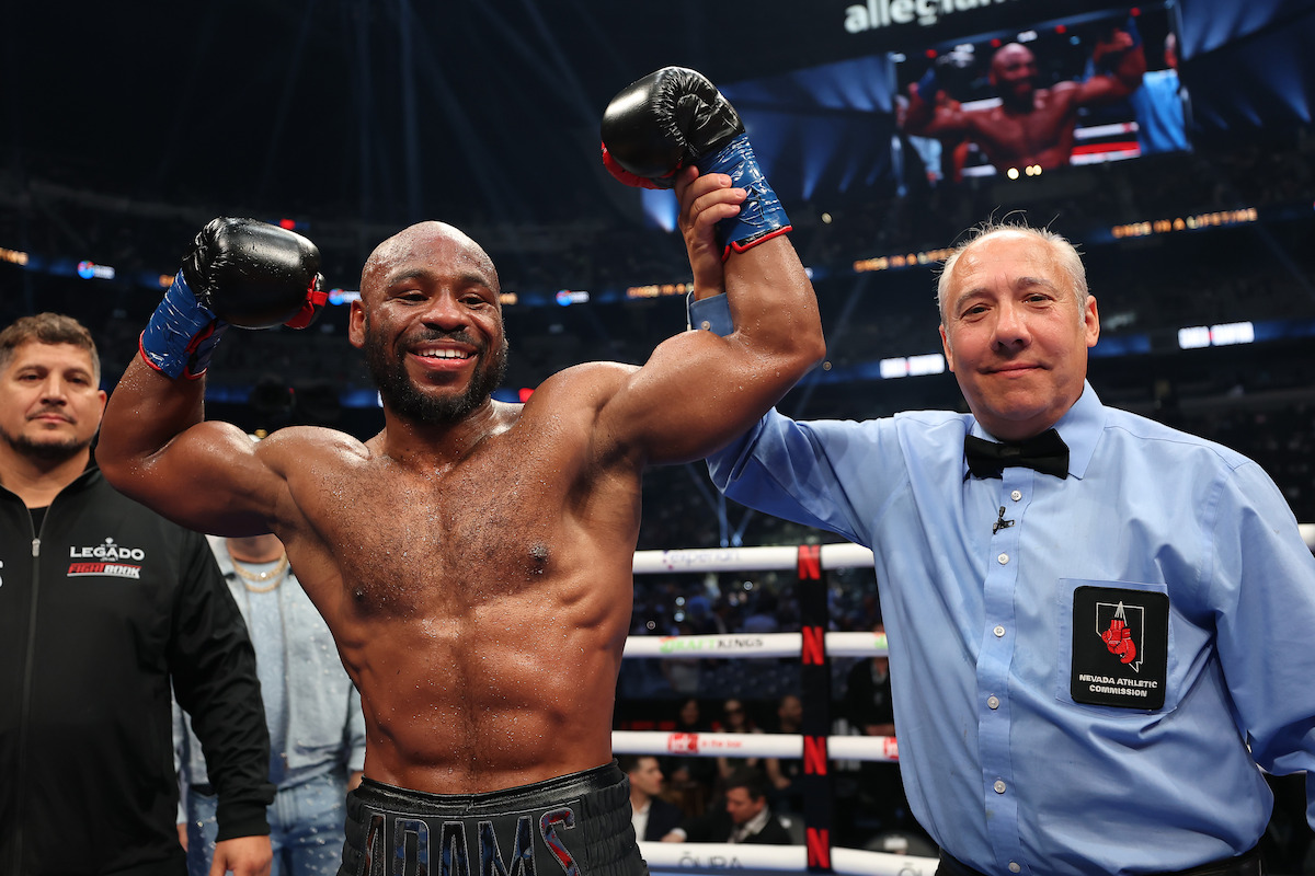 The referee raises the arm of Brandon Adams in honor of his win by unanimous decision.