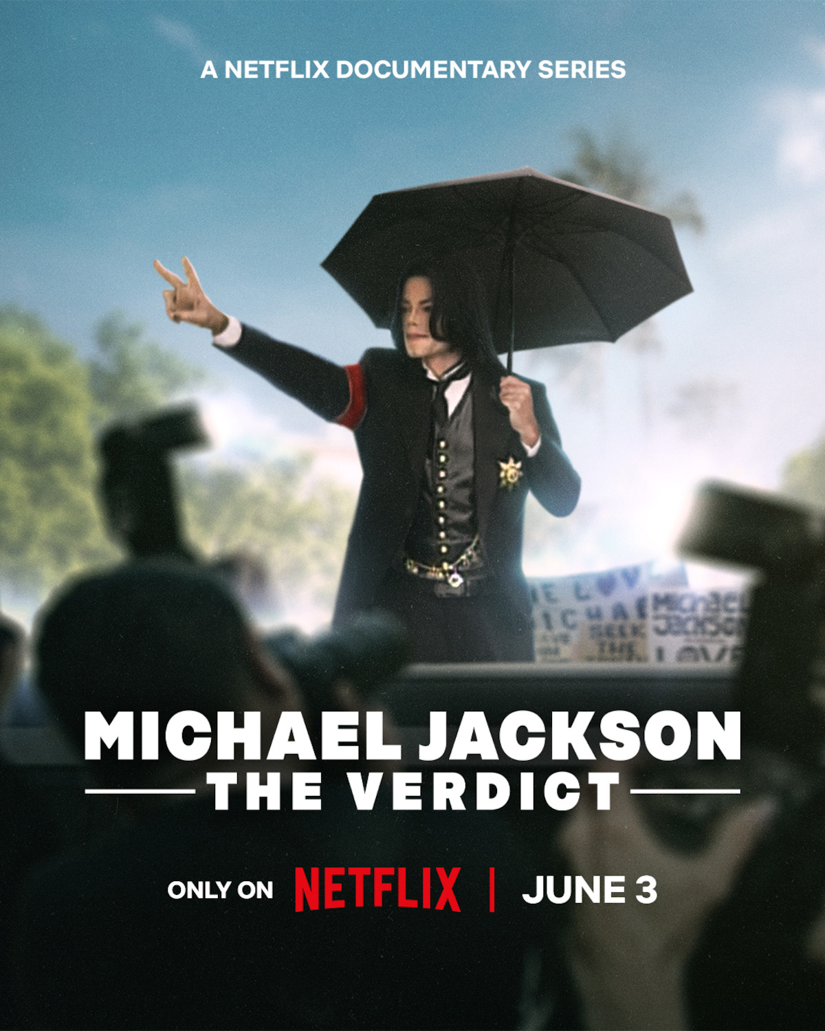 A person in formal attire holds an umbrella outdoors, raising one hand, surrounded by cameras and blurred onlookers. The scene promotes a Netflix documentary titled "Michael Jackson: The Verdict," streaming June 3.