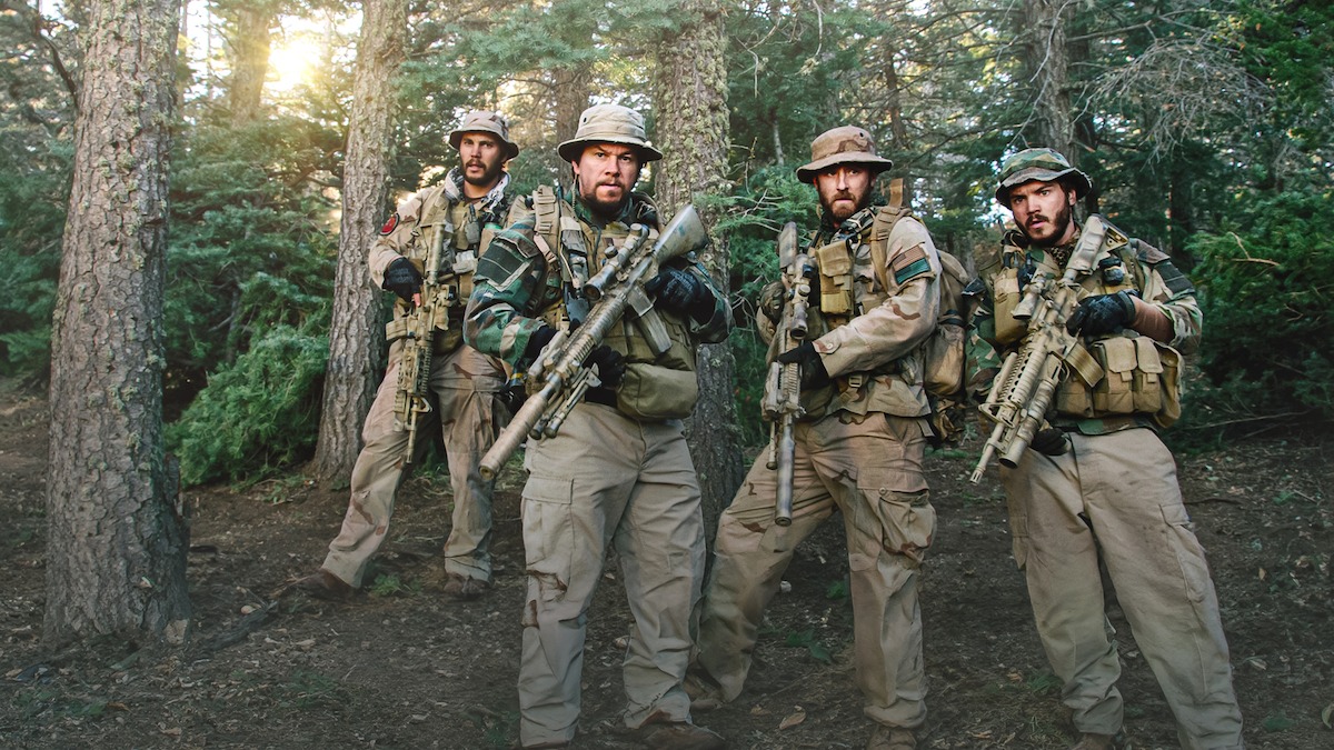Mark Wahlberg as Marcus, Taylor Kitsch as Murph, Emile Hirsch as Danny, and Ben Foster as Axe proceed through the woods with caution in ‘Lone Survivor.’