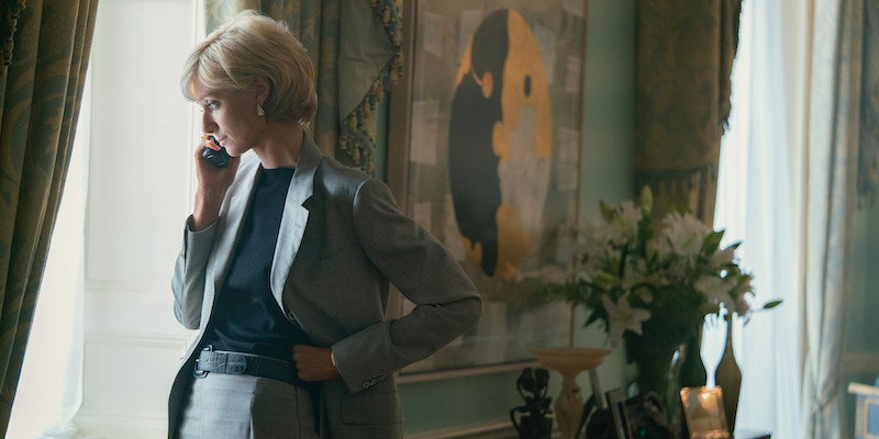 Gray suit with black blouse and white handbag