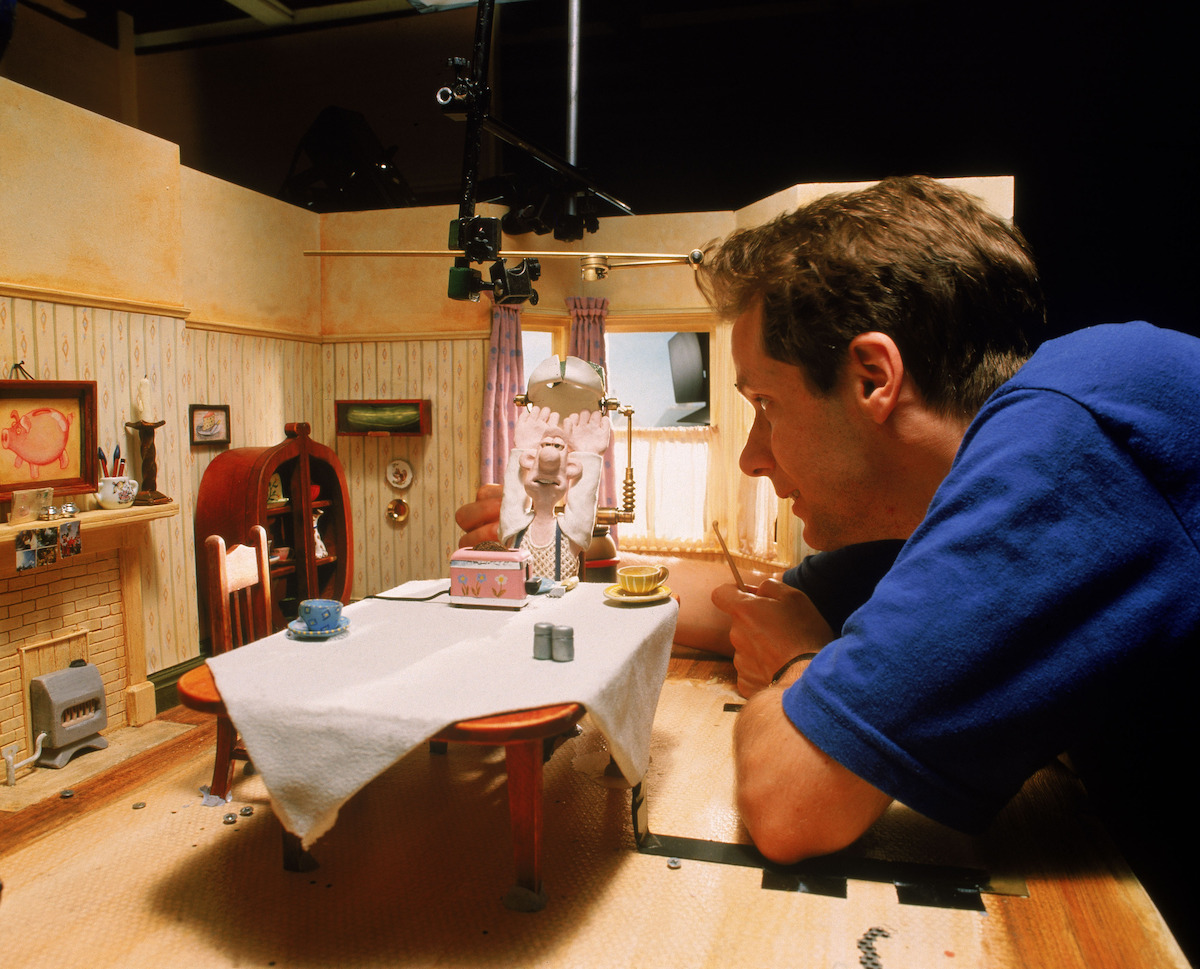 Nick Park wears a blue shirt on set.