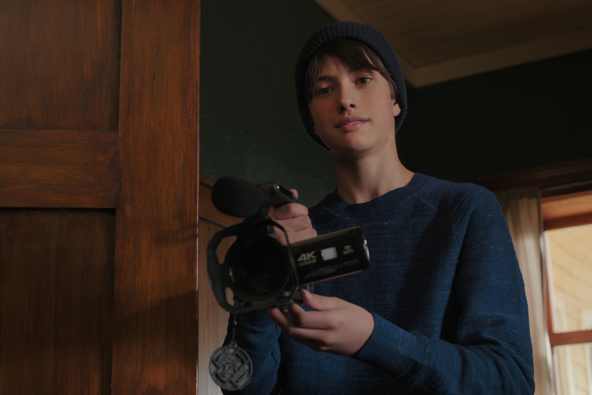 Dean Petriw as Jordan holds a video camera in ‘My Life with the Walter Boys’ Season 1.