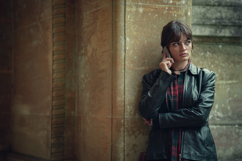 woman leaning on wall on phone