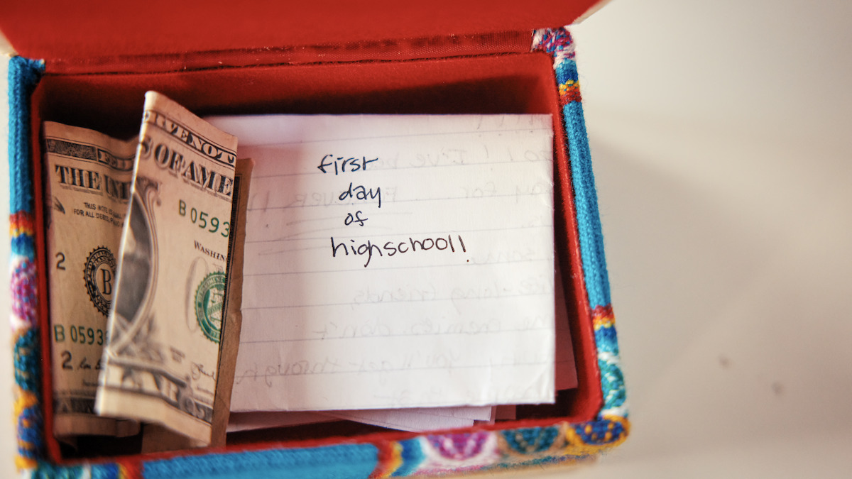 A keepsake box with a letter that says “first day of high school” in it.