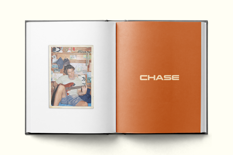 Open photo book showing a young man playing guitar in a casual, decorated room on the left page and an orange right page with the word CHASE in large text, suggesting a personal or themed scrapbook.