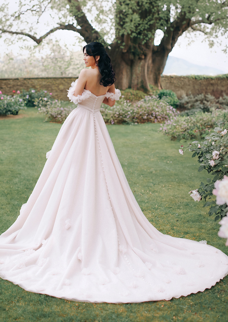Woman in bridal dress looks over her shoulder.