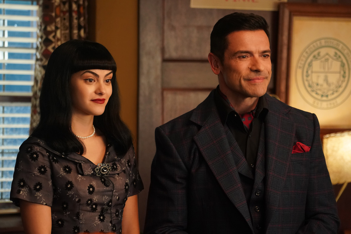 Camila Mendes as Veronica Lodge and Mark Consuelos as Hiram Lodge stand together in Season 7 of ‘Riverdale.’