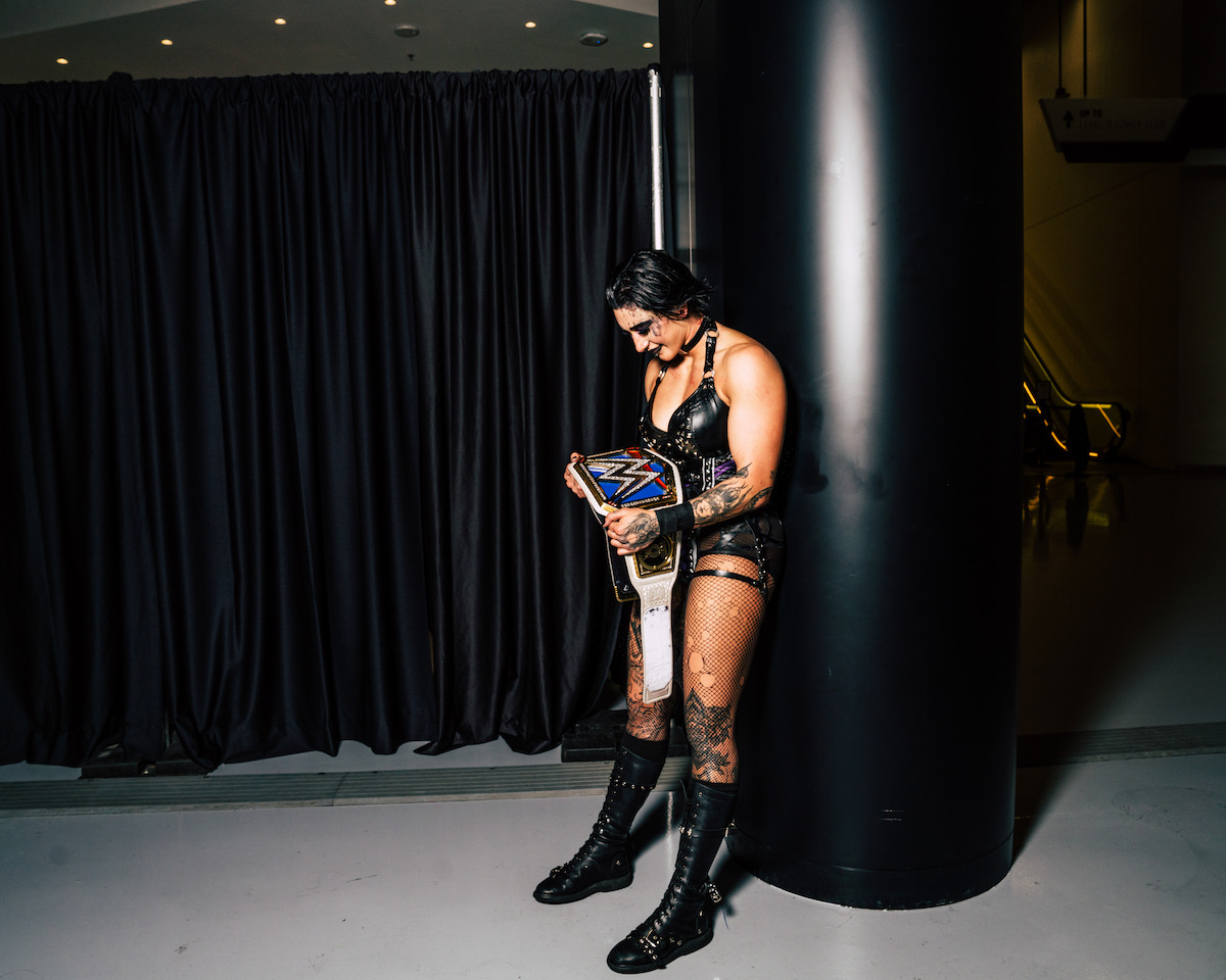 Rhea Ripley admiring her belt backstage.
