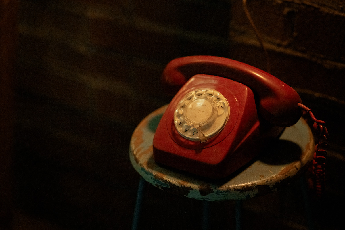 A red telephone sits on a table in ‘Boy Swallows Universe’