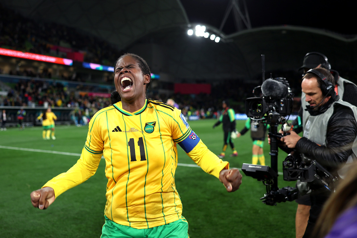 A player in a Brazil soccer jersey on a field looking triumphant.