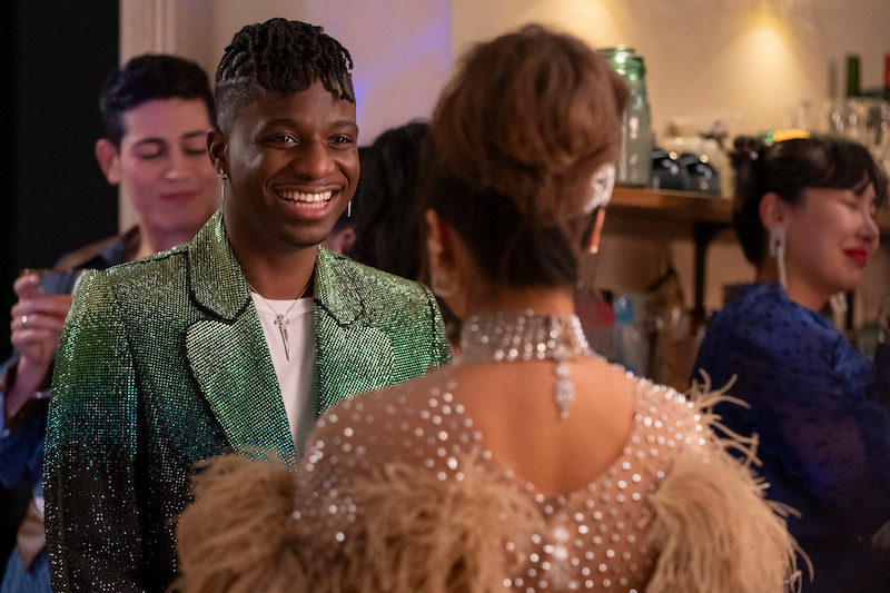 Samuel Arnold as Julien smiles at a party in Season 4 of 'Emily in Paris'